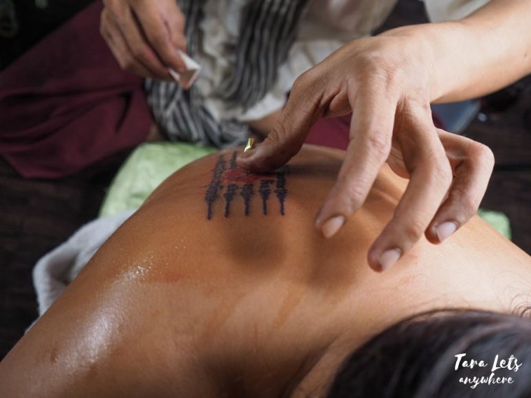 Putting gold foil in Sak Yant tattoo